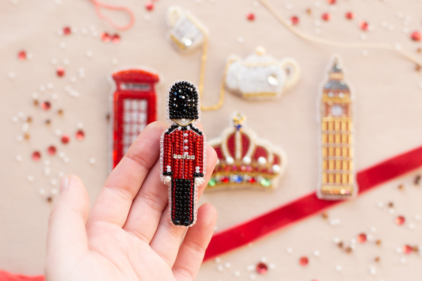 a hand holding a beaded toy of a british soldier