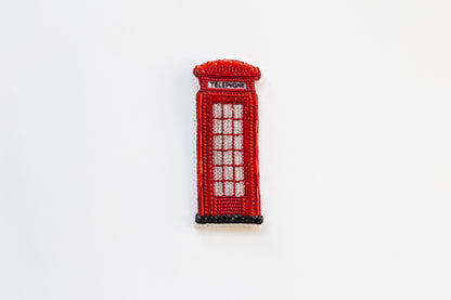 a red beaded phone booth on a white surface