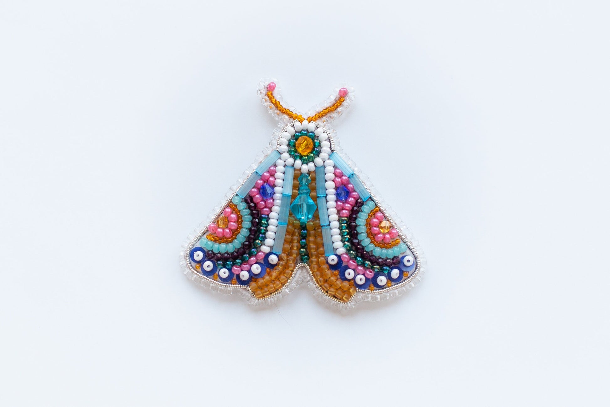 a multicolored beaded butterfly on a white background