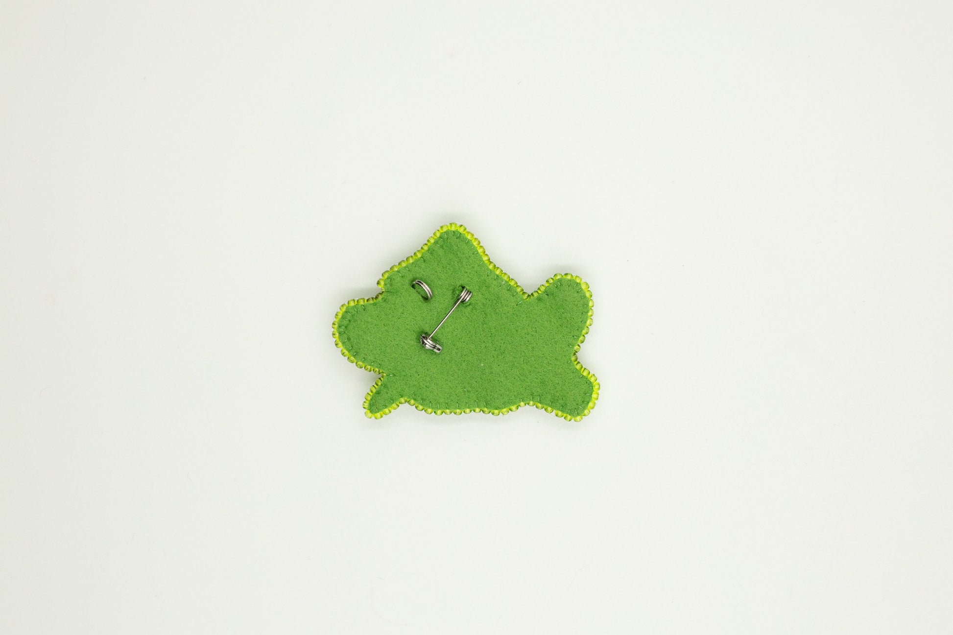 a green piece of felt with a button on it