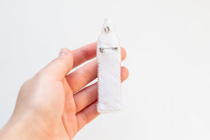 a person holding a piece of cloth with a pin in it