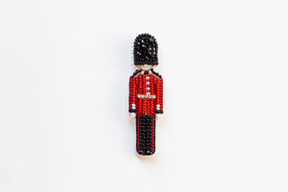 a beaded figure of a man in a red uniform