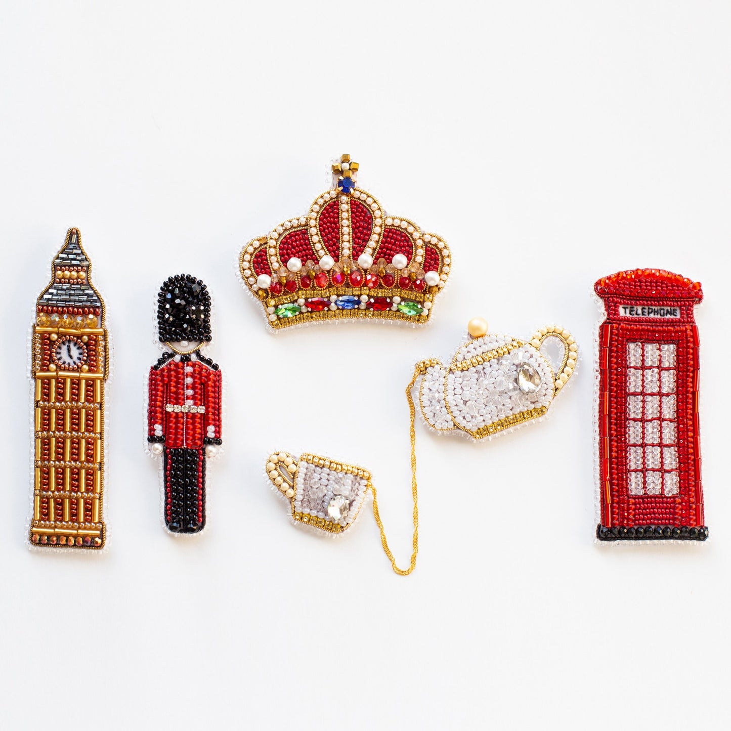 a collection of beaded pins including a british flag, a british guard, a