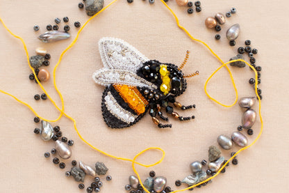 a beaded bee sitting on top of a yellow string