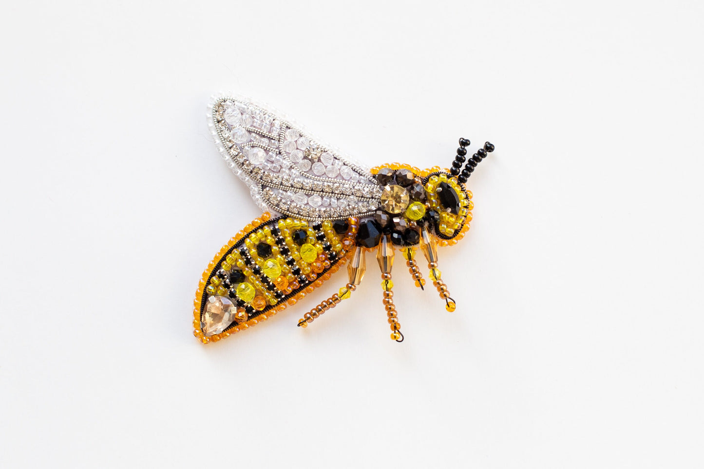 a beaded insect sitting on top of a white surface