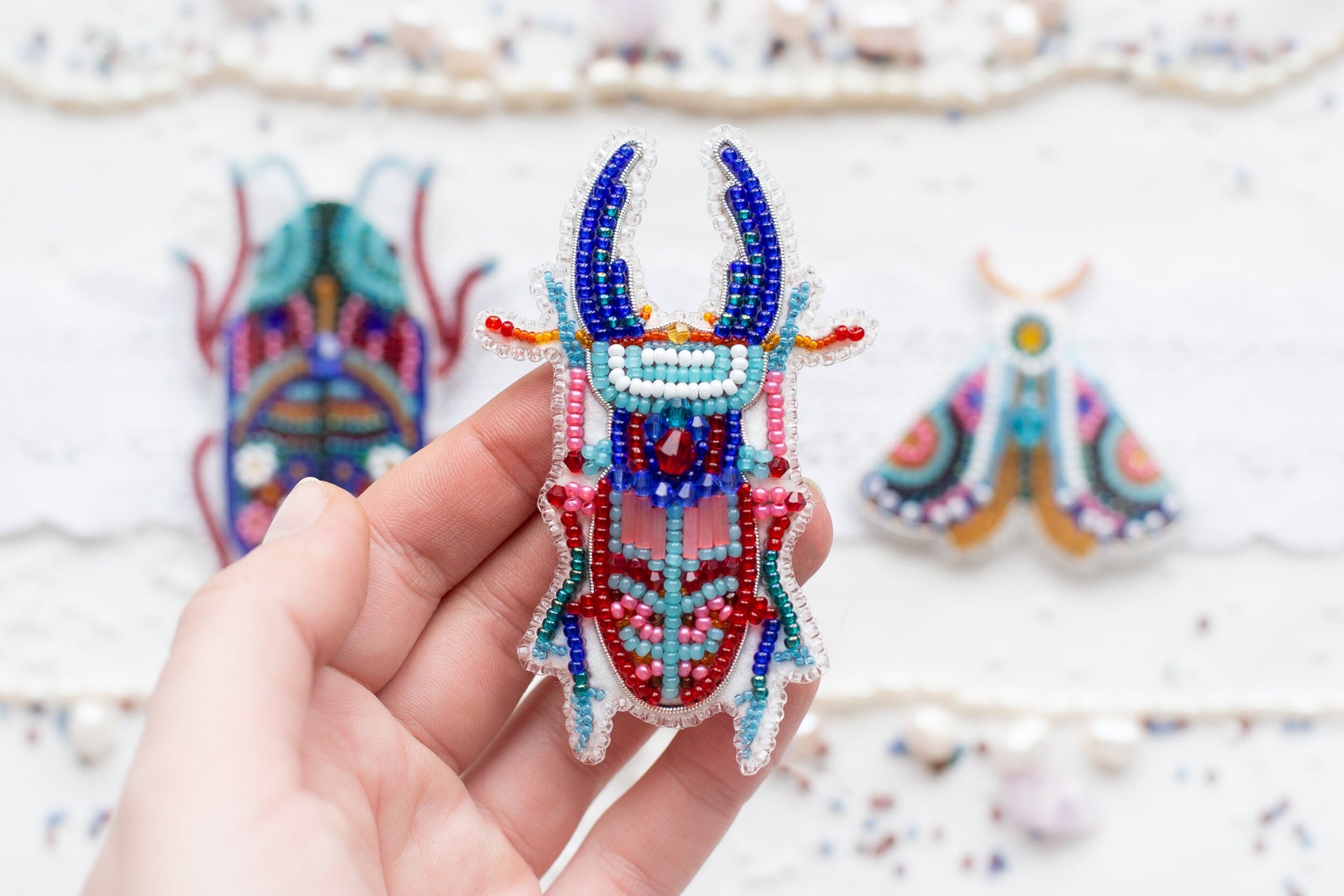 a person holding a beaded animal in their hand