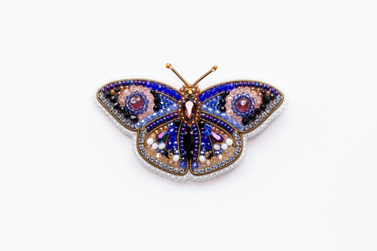 a colorful butterfly brooch sitting on top of a white surface