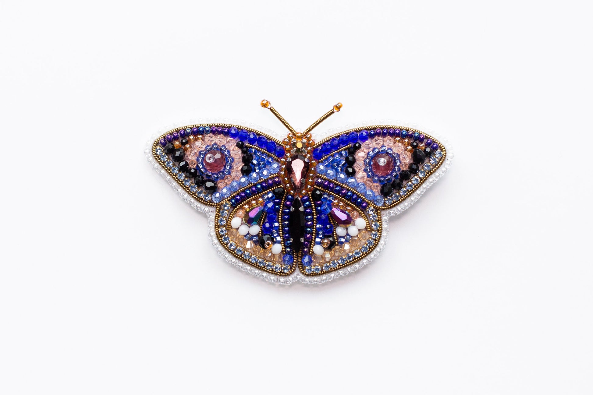 a colorful butterfly brooch sitting on top of a white surface