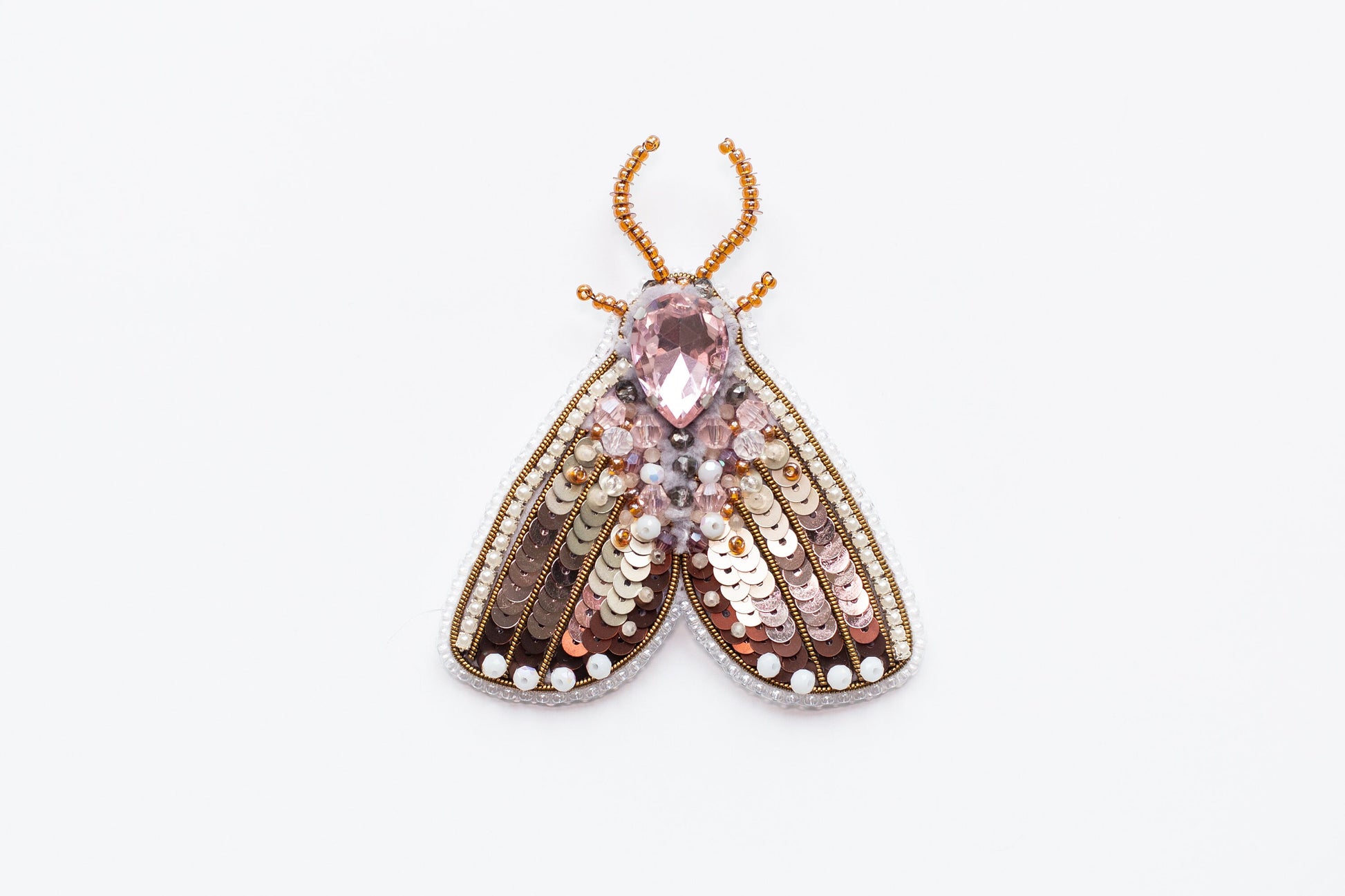 a brooch with a pink and brown insect on it