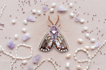 a butterfly brooch surrounded by pearls and pearls