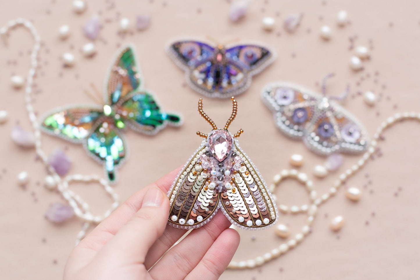 a person is holding a butterfly brooch in their hand