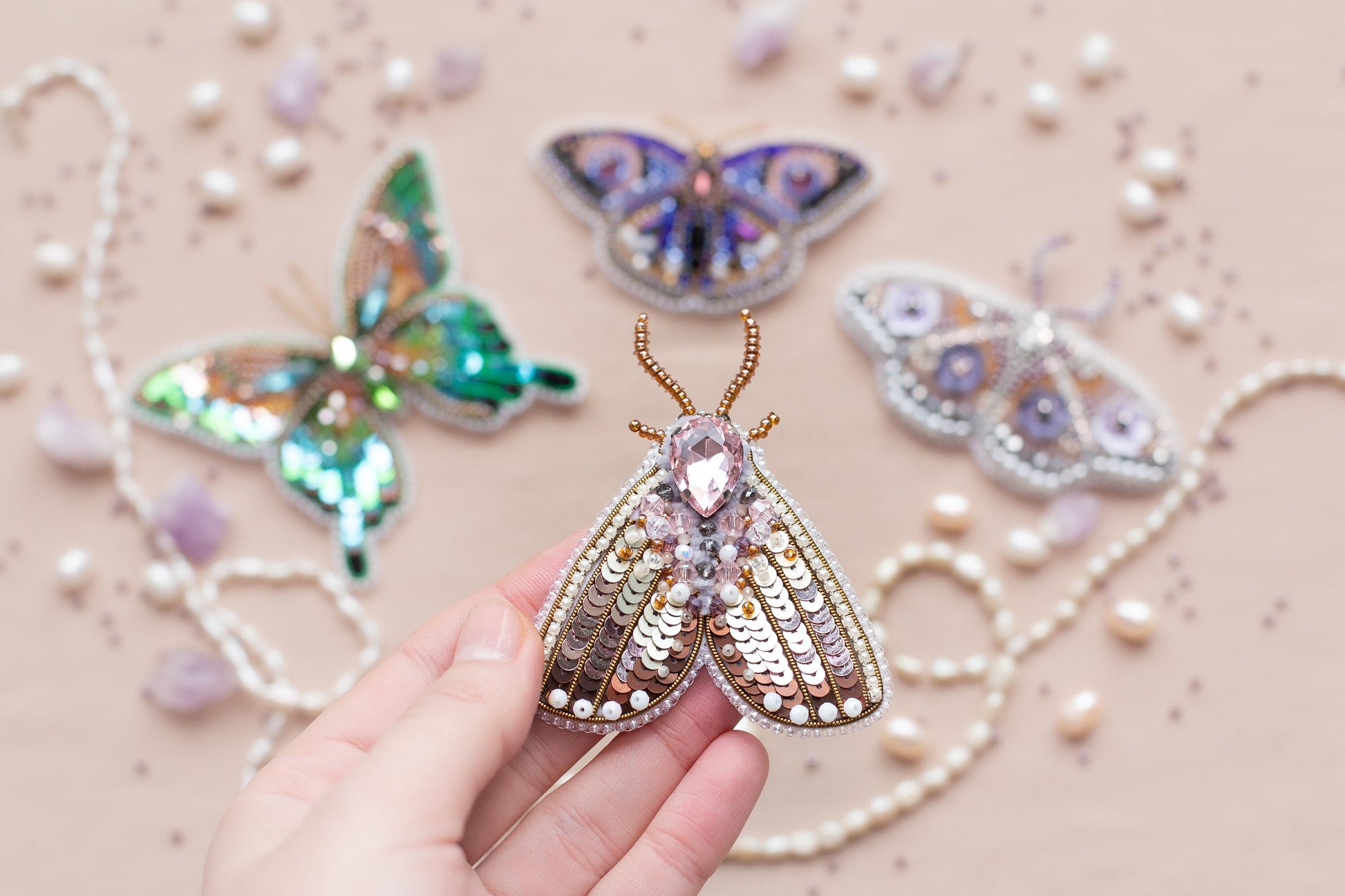 a person is holding a butterfly brooch in their hand