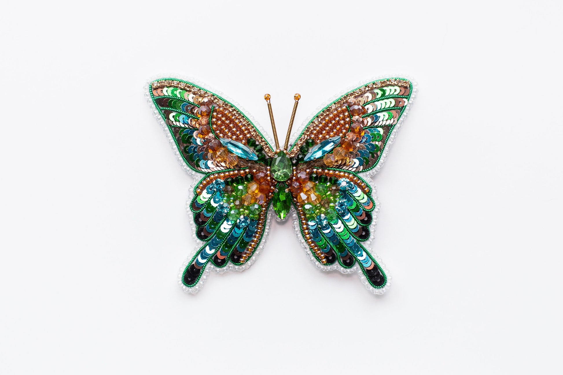 a colorful butterfly brooch sitting on top of a white surface