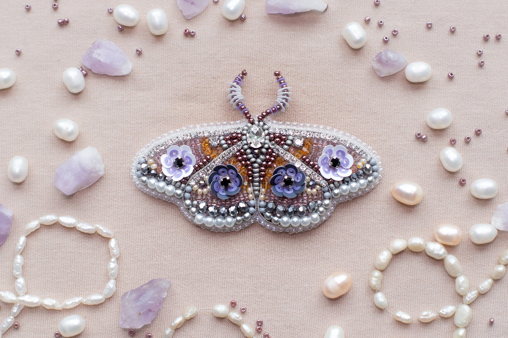 a beaded butterfly sitting on top of a table