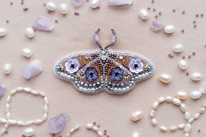 a beaded butterfly sitting on top of a table