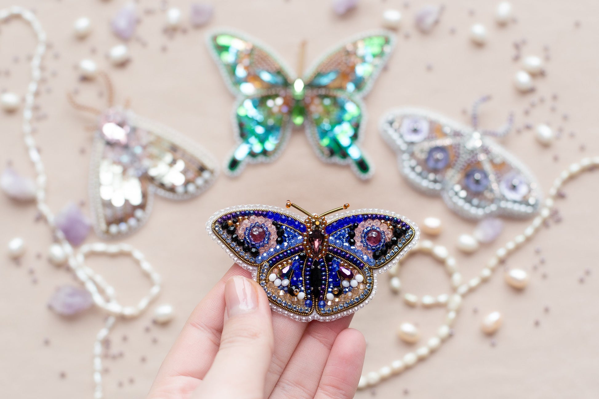 a person holding a butterfly brooch in their hand