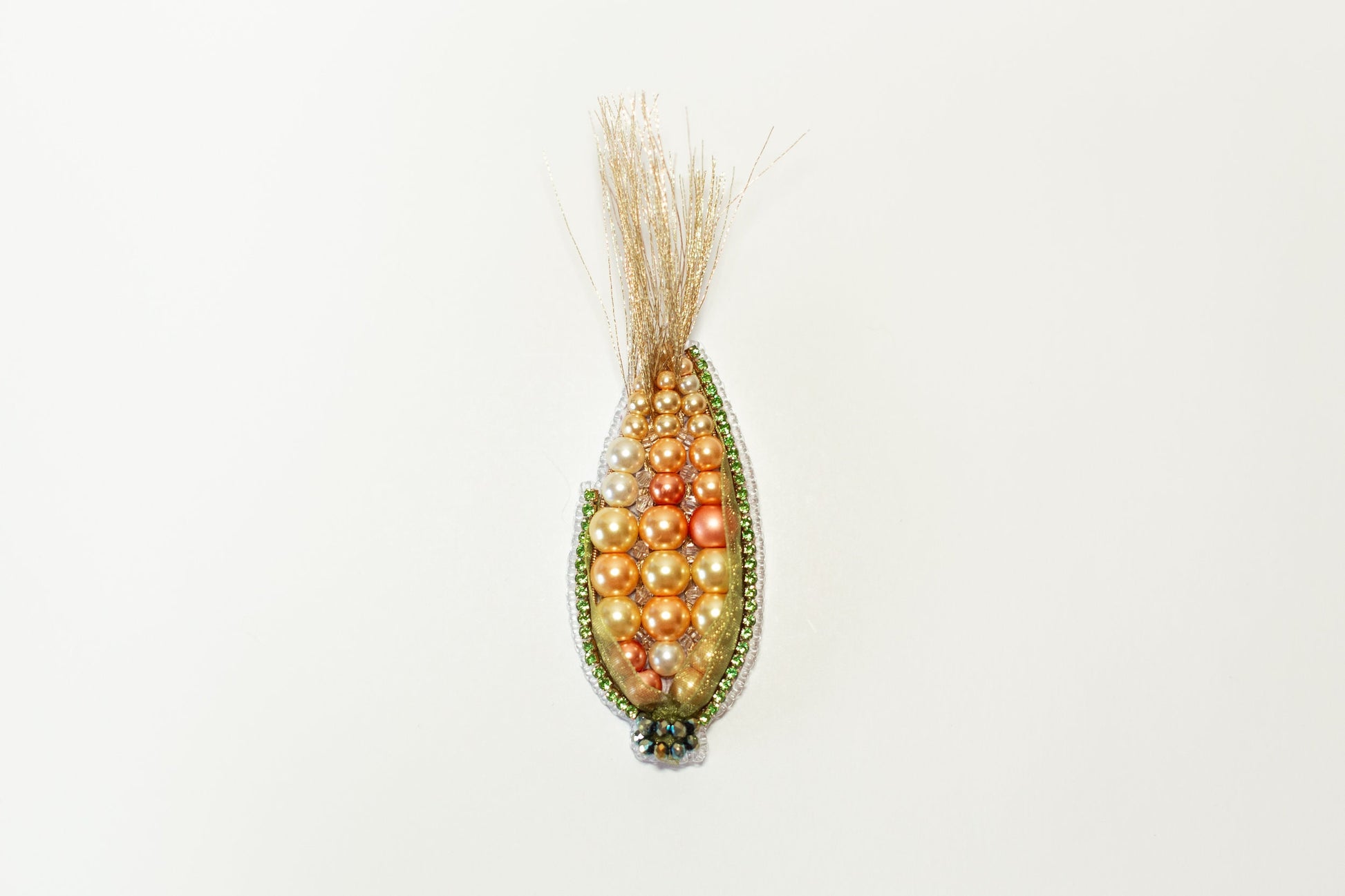 a beaded corn cob hanging on a wall