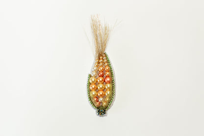 a beaded corn cob hanging on a wall