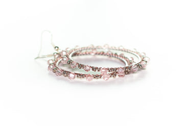 a pair of pink beaded bracelets on a white background