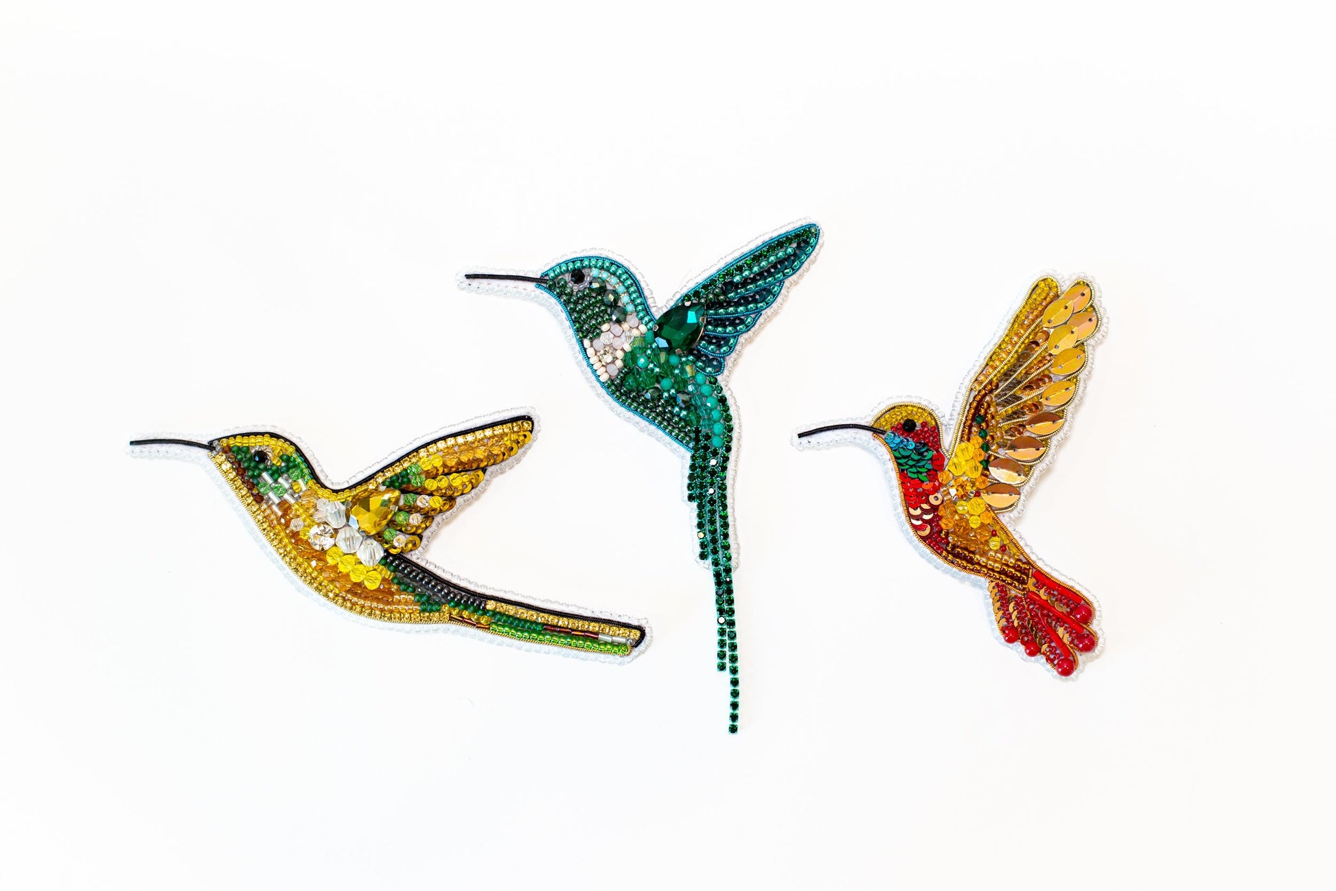 three colorful birds are flying in the air