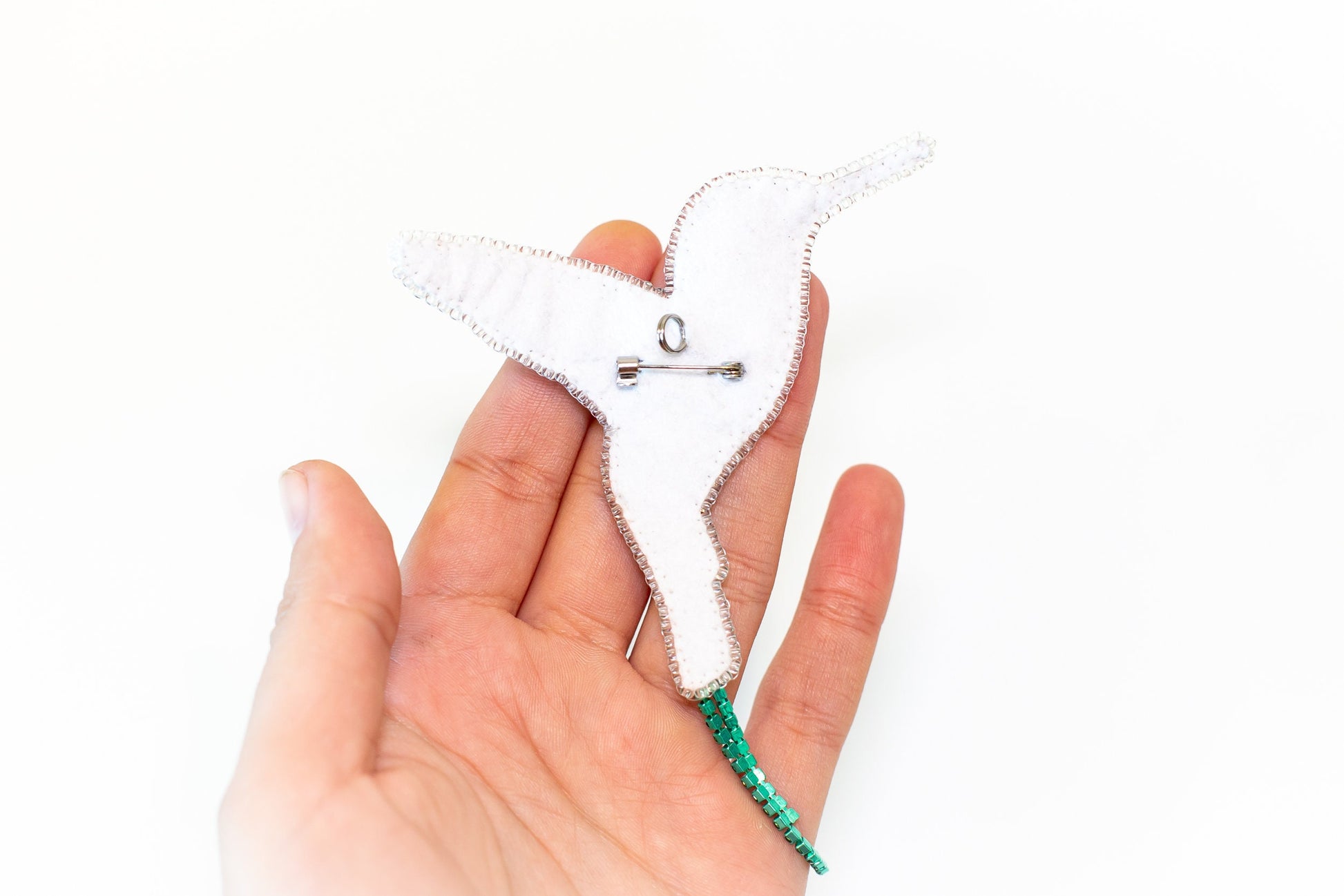 a hand holding a small white star ornament