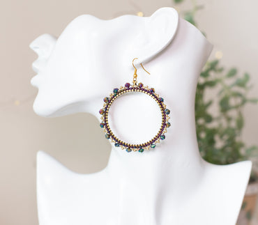 a white mannequin head with a pair of earrings on it