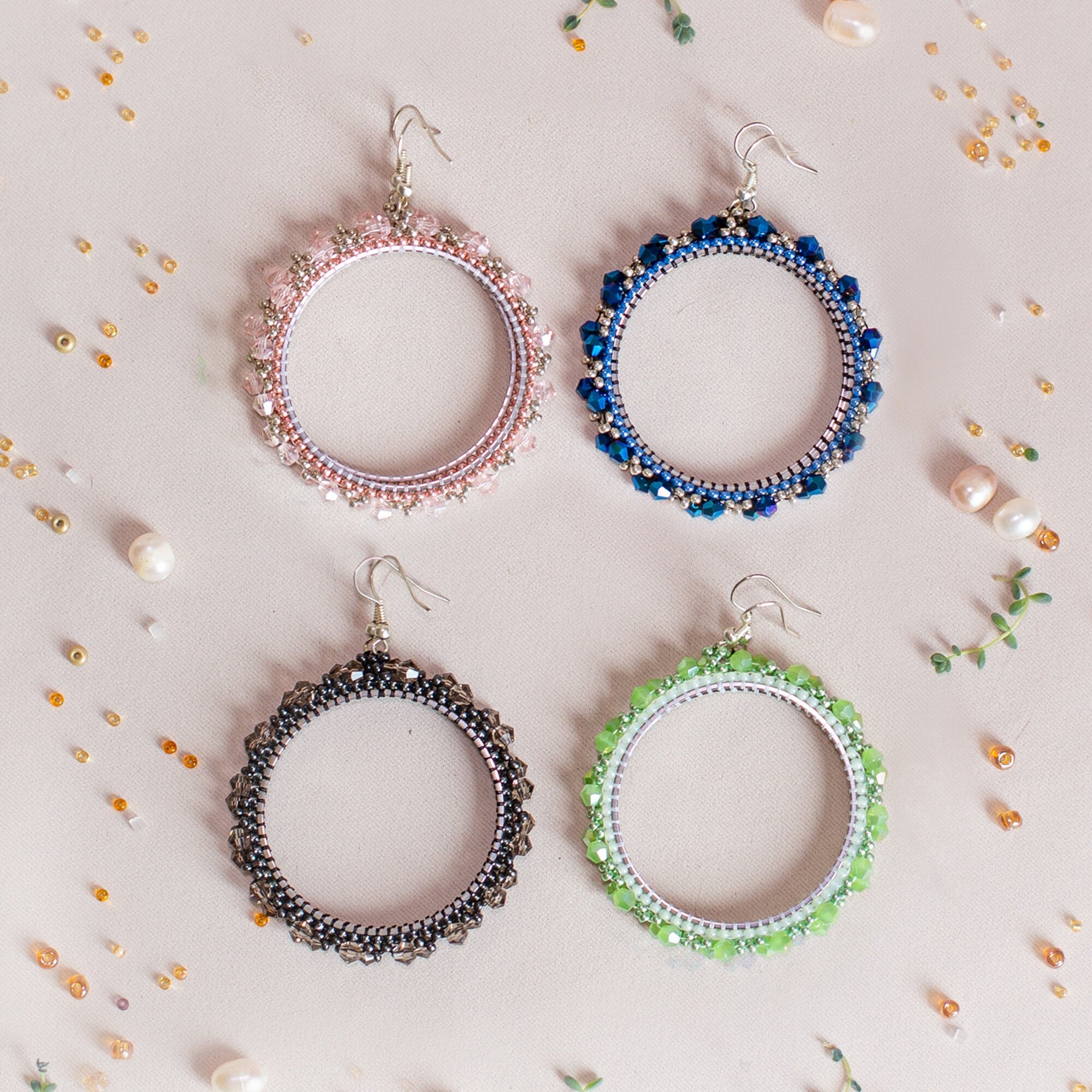 six pairs of beaded hoop earrings on a white background