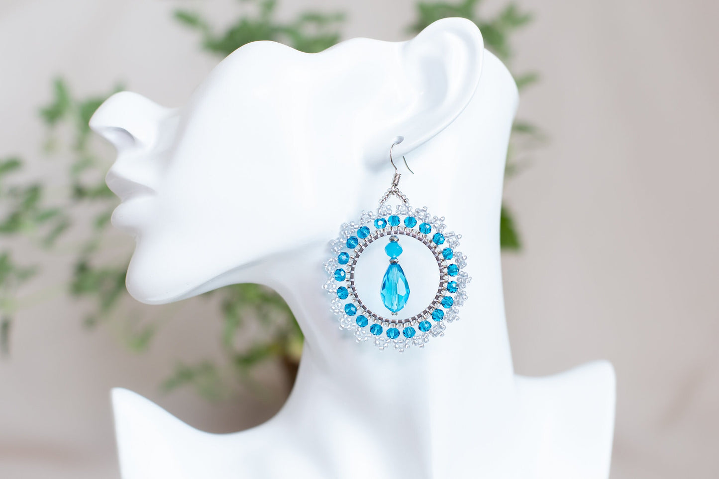 a close up of a pair of earrings on a mannequin head