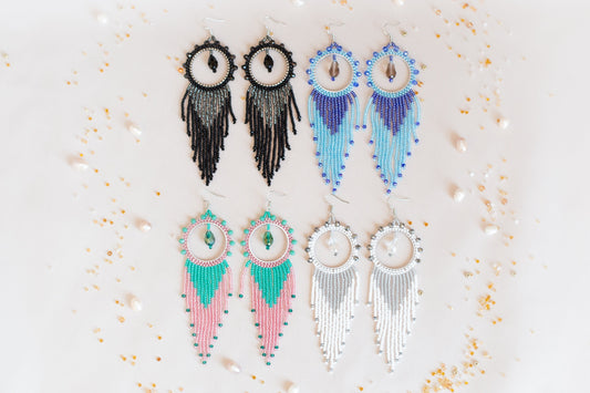 four pairs of earrings are displayed on a white surface