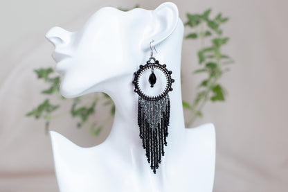 a close up of a pair of earrings on a mannequin head