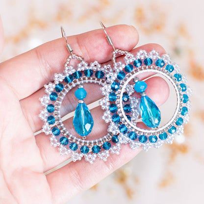 a pair of earrings with a picture of a woman on it