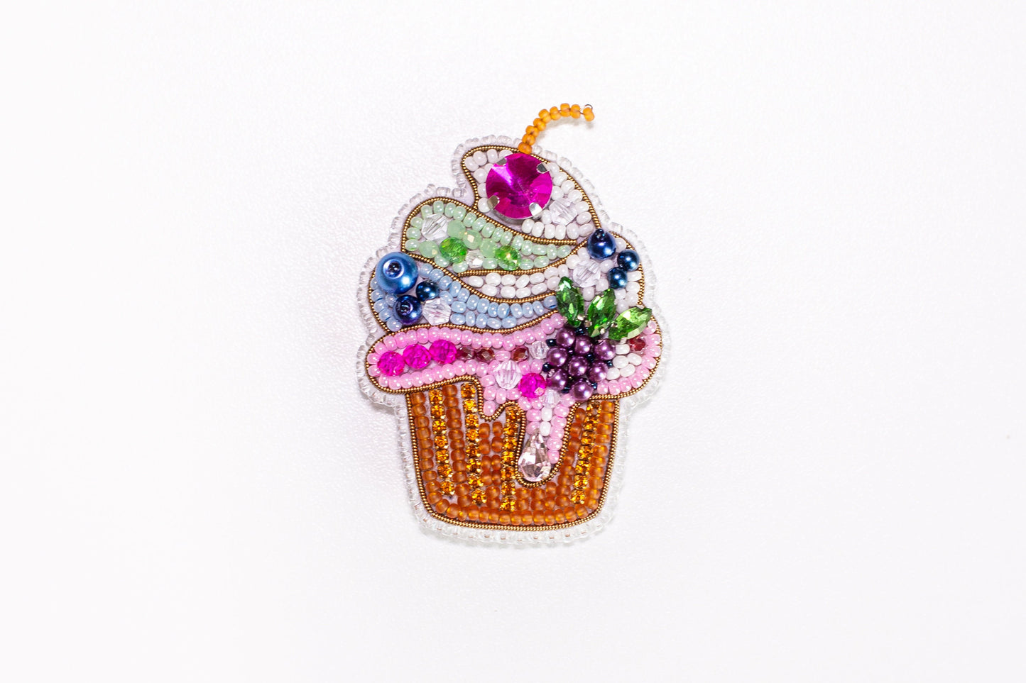 a pin with a cupcake on it on a white surface