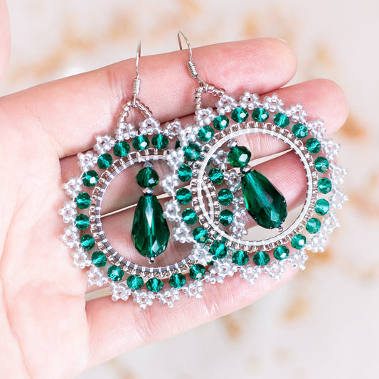 a pair of green and white earrings sitting on top of a table