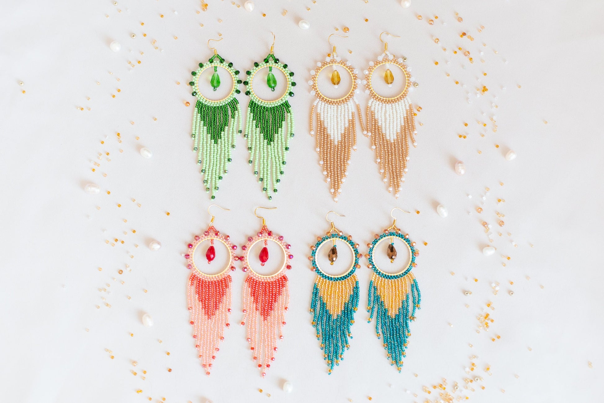 three pairs of beaded earrings on a white surface