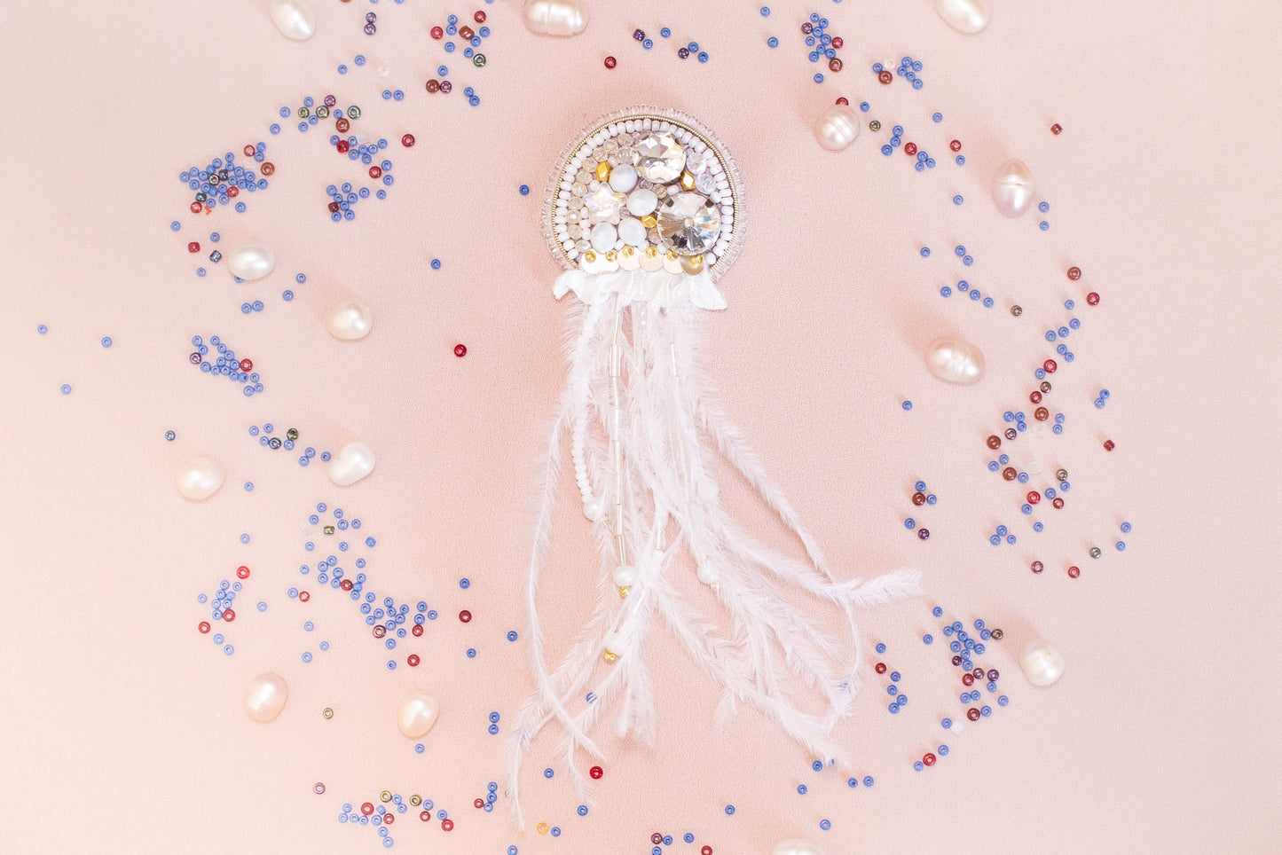 a brooch with pearls and pearls on a pink background