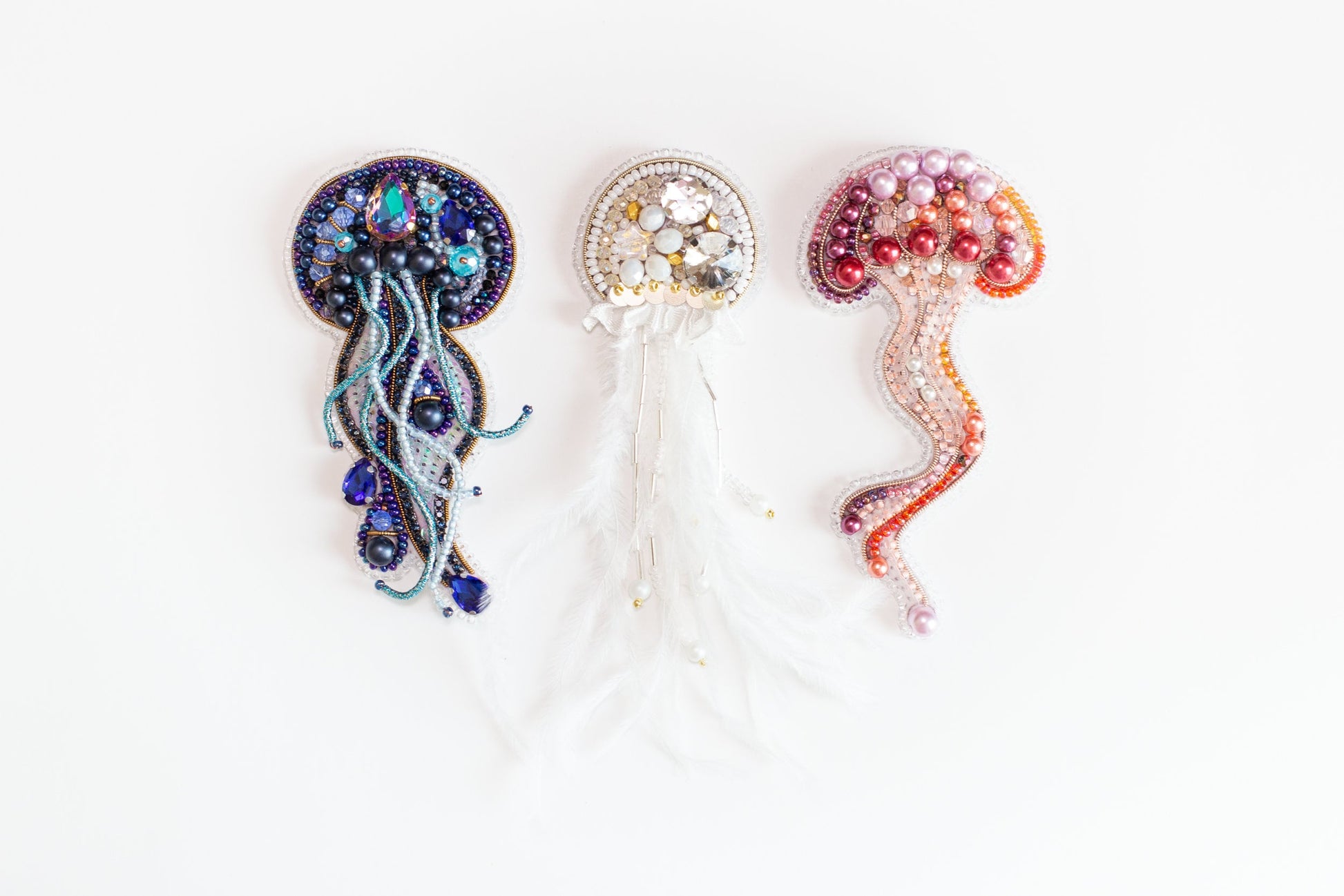 three beaded brooches on a white background