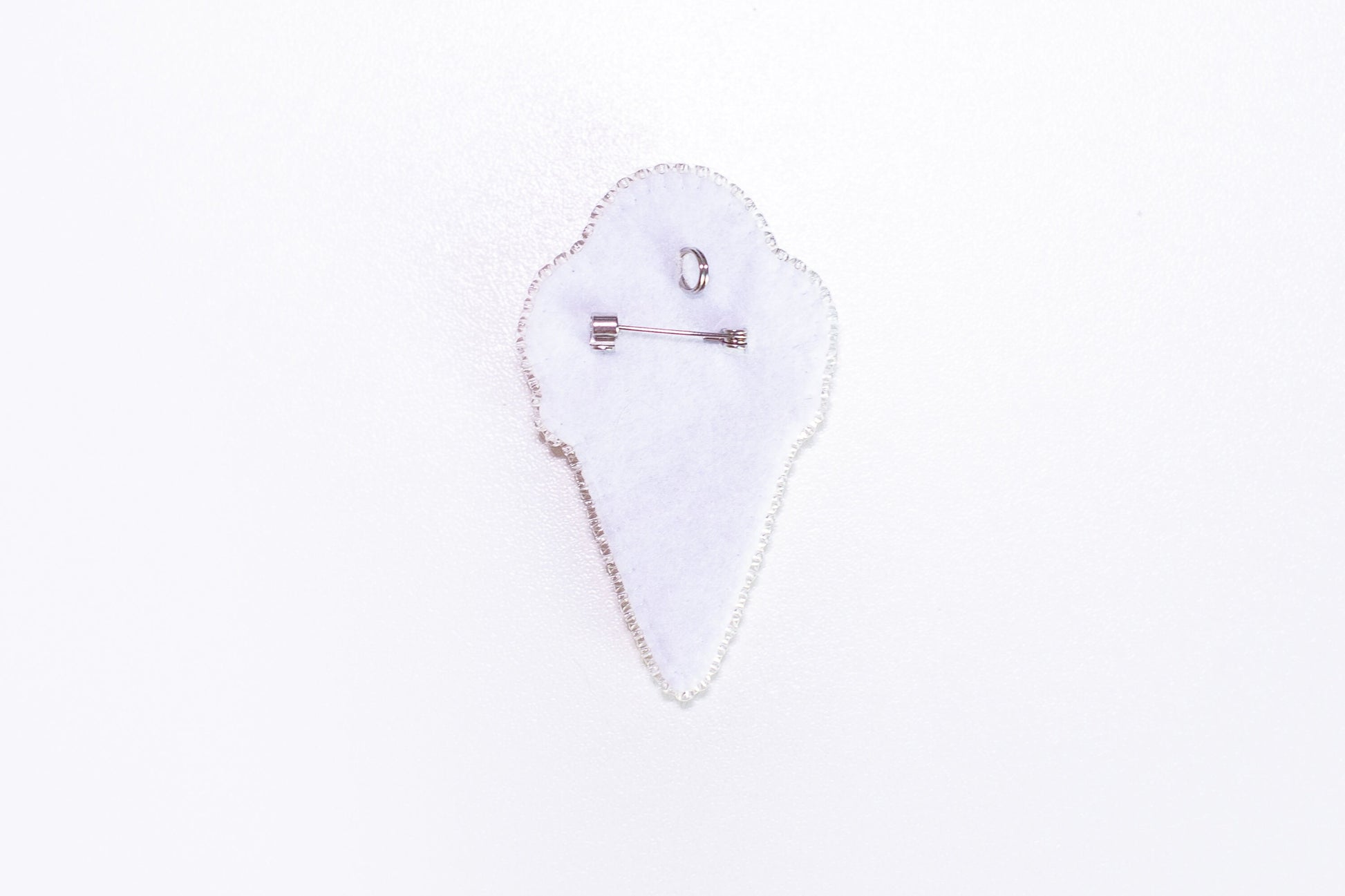 a white piece of cloth with a pin on it