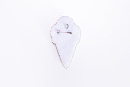 a white piece of cloth with a pin on it