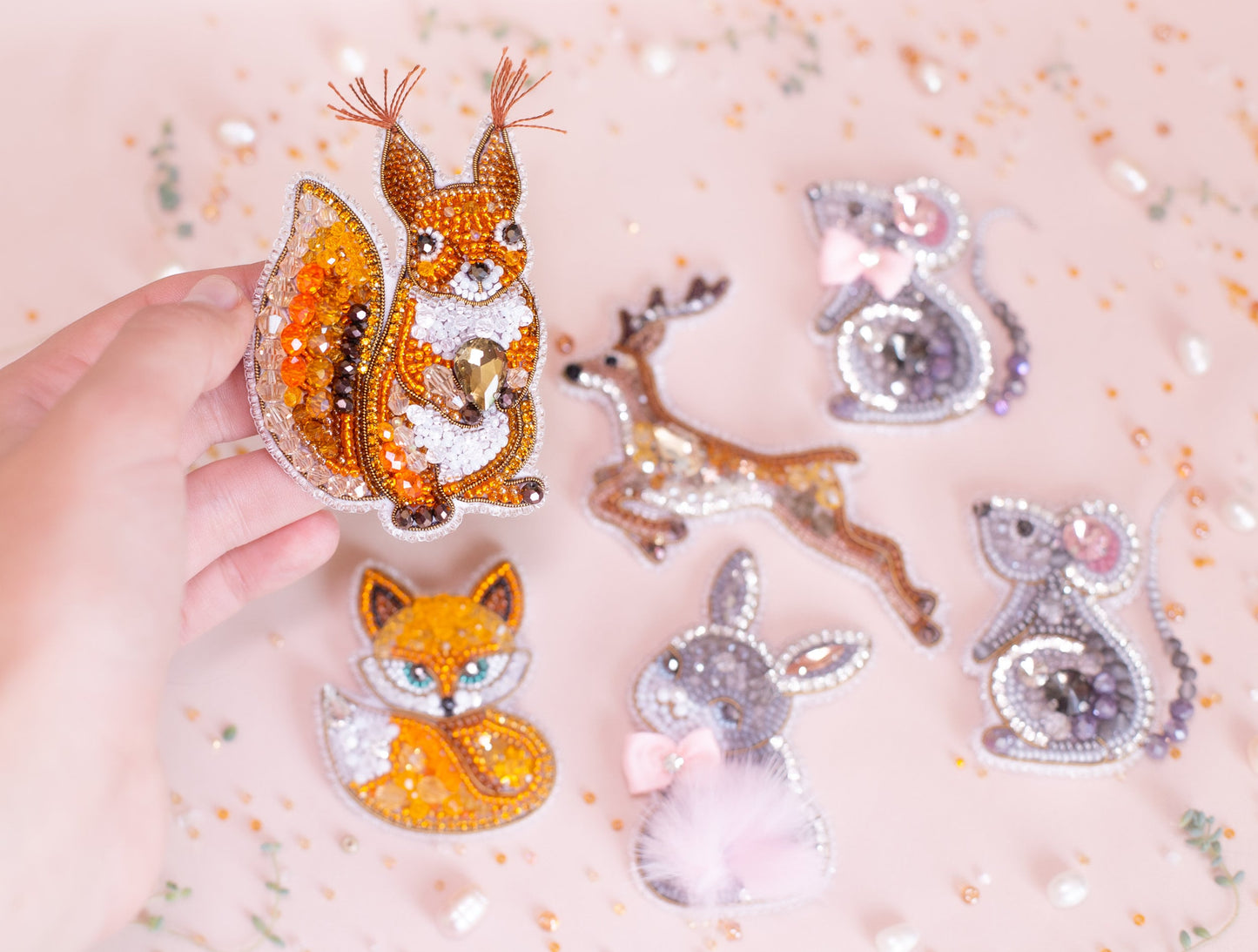 a person holding a small assortment of animal brooches