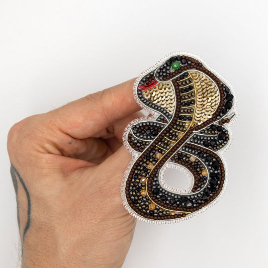 a hand holding a sticker with a snake on it