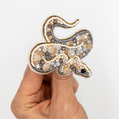 a person is holding a brooch in their hand